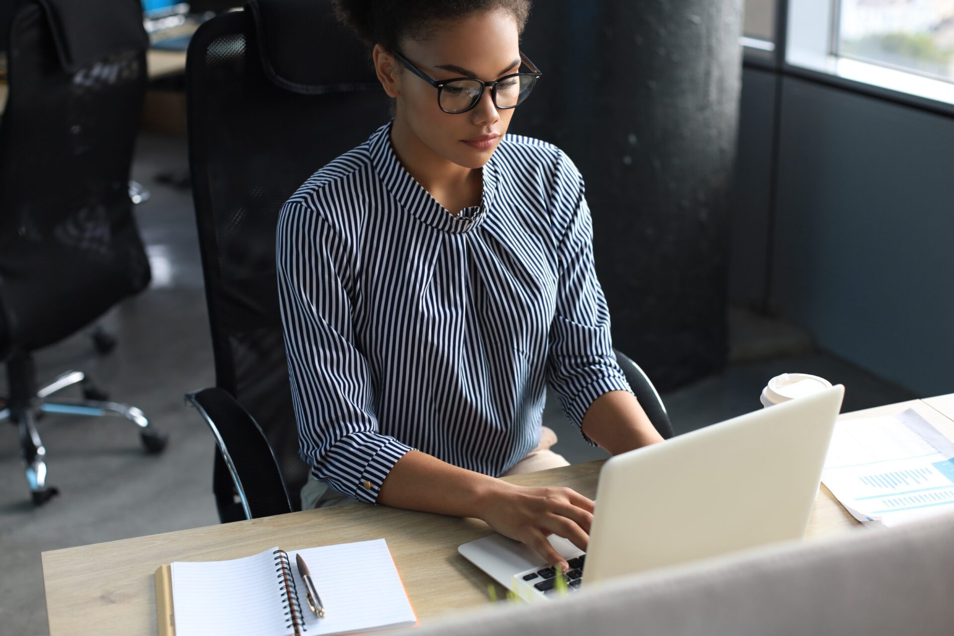 Portrait of beautiful young african american woman working with laptop while sitting at the table